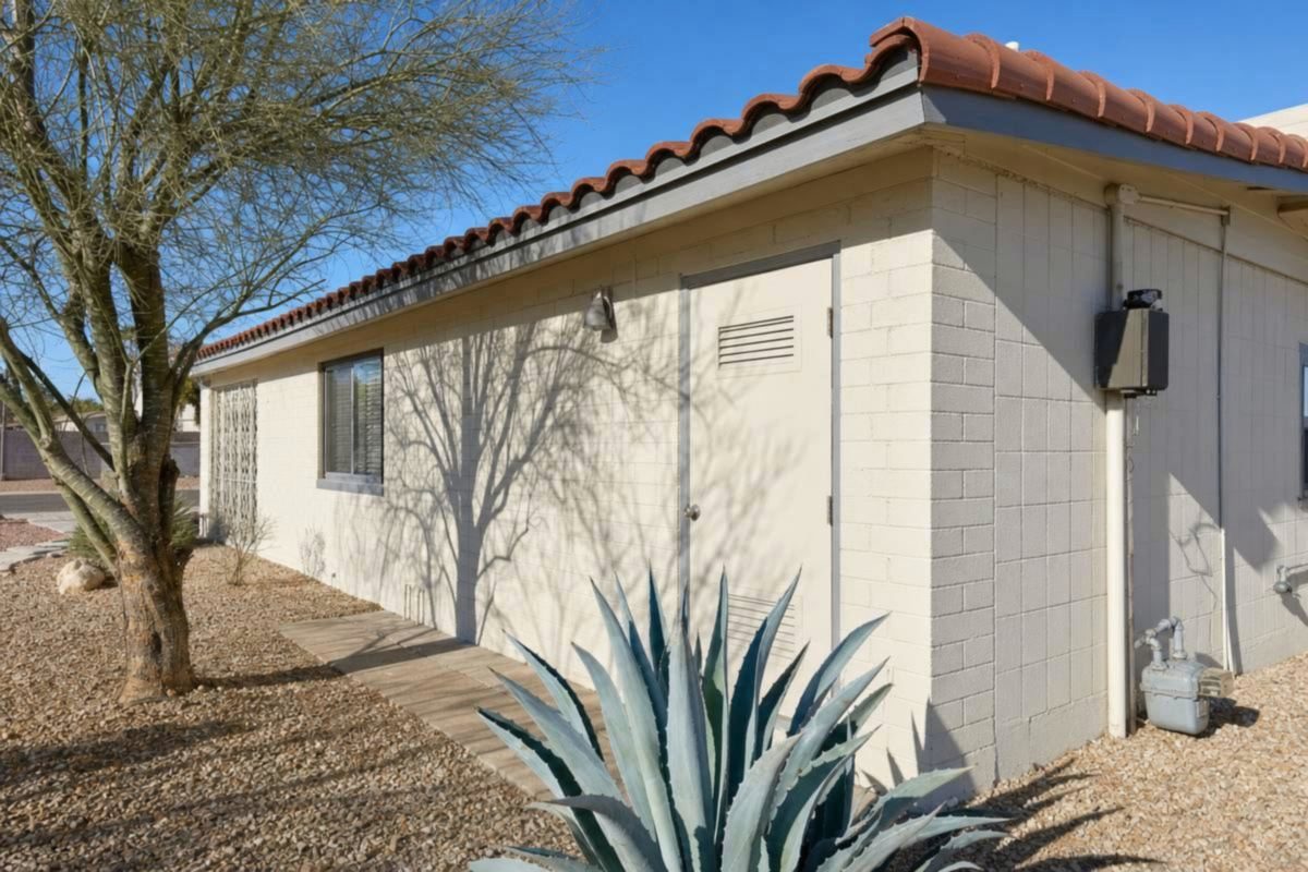 A single-story Arizona block house with a desert gravel yard